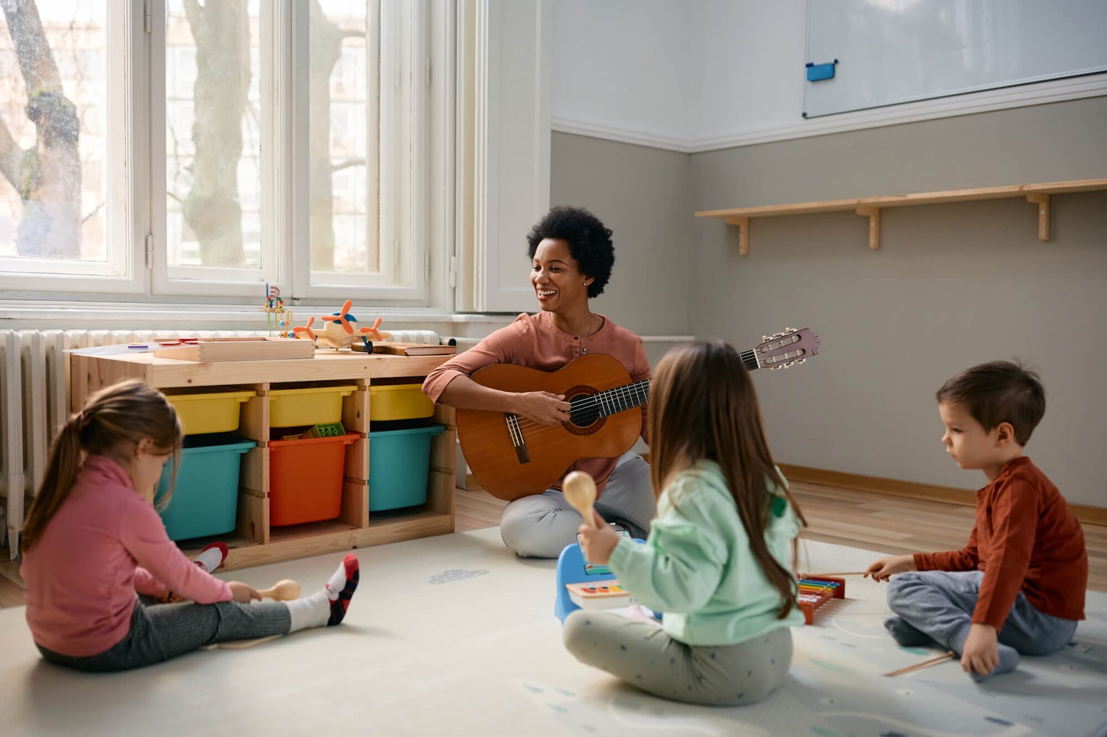 happy-black-teacher-and-group-of-kids-enjoying-during-music-class-at-kindergarten-.jpg