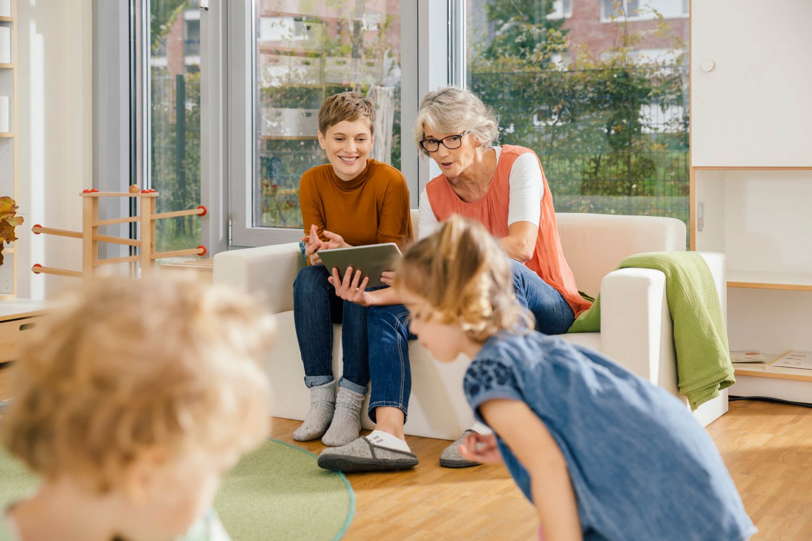 pre-school-teachers-with-tablet-looking-at-children-in-kindergarten.jpg